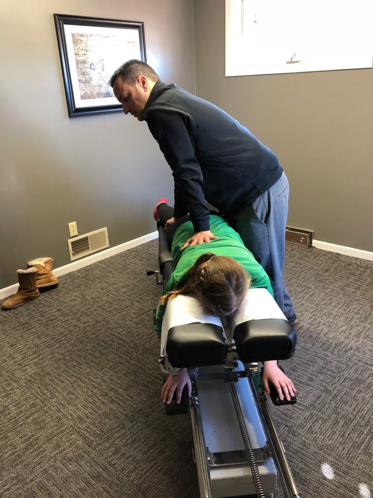 Dr. Hauser performing a chiropractic adjustment at De Pere Chiropractic Center
